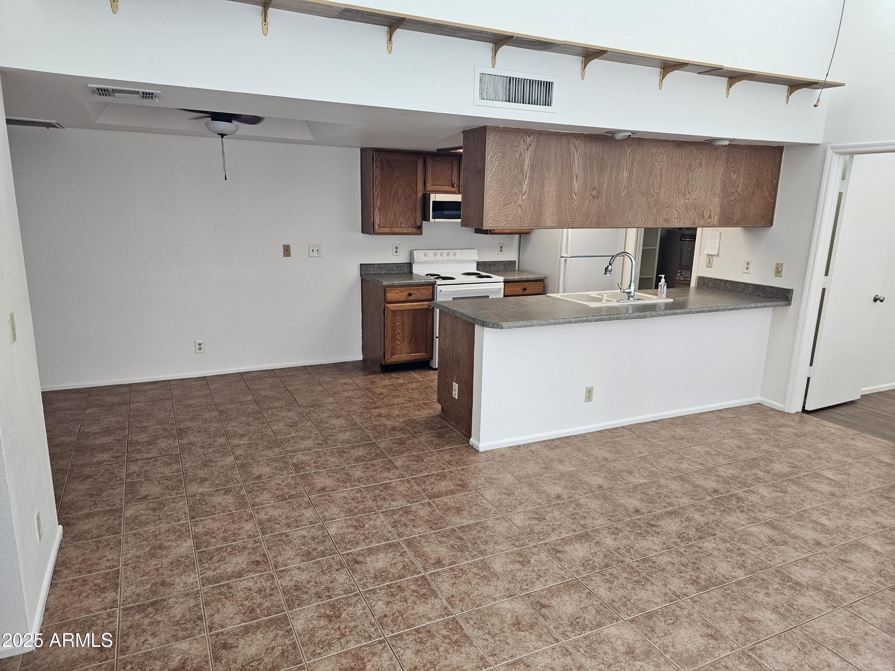633 West Southern Avenue, Unit 1118 Tempe, AZ 85282 - Photo 4 of 12 a kitchen with a stove a sink and a refrigerator