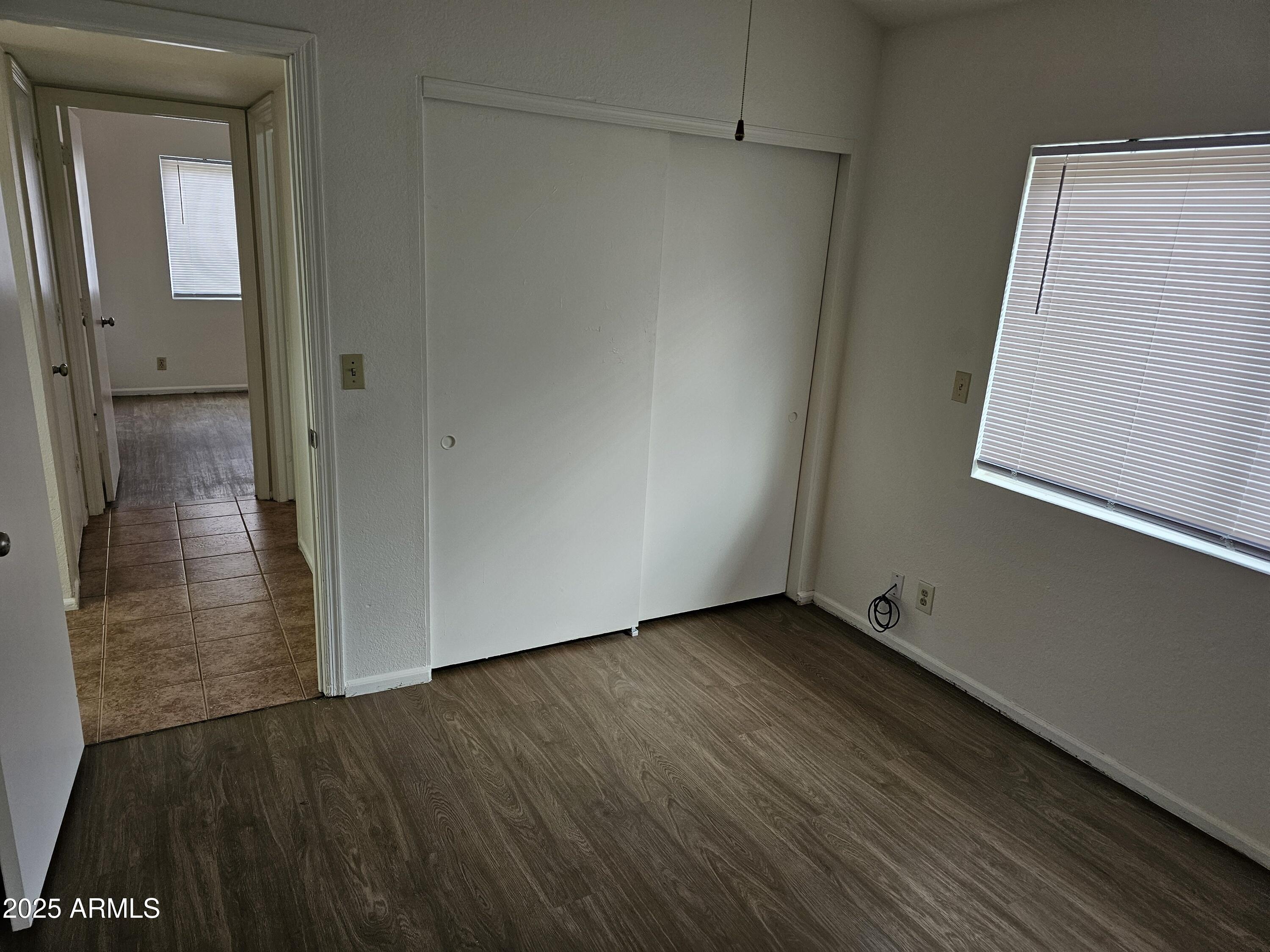 633 West Southern Avenue, Unit 1118 Tempe, AZ 85282 - Photo 9 of 12 a view of an empty room with wooden floor and a bathroom