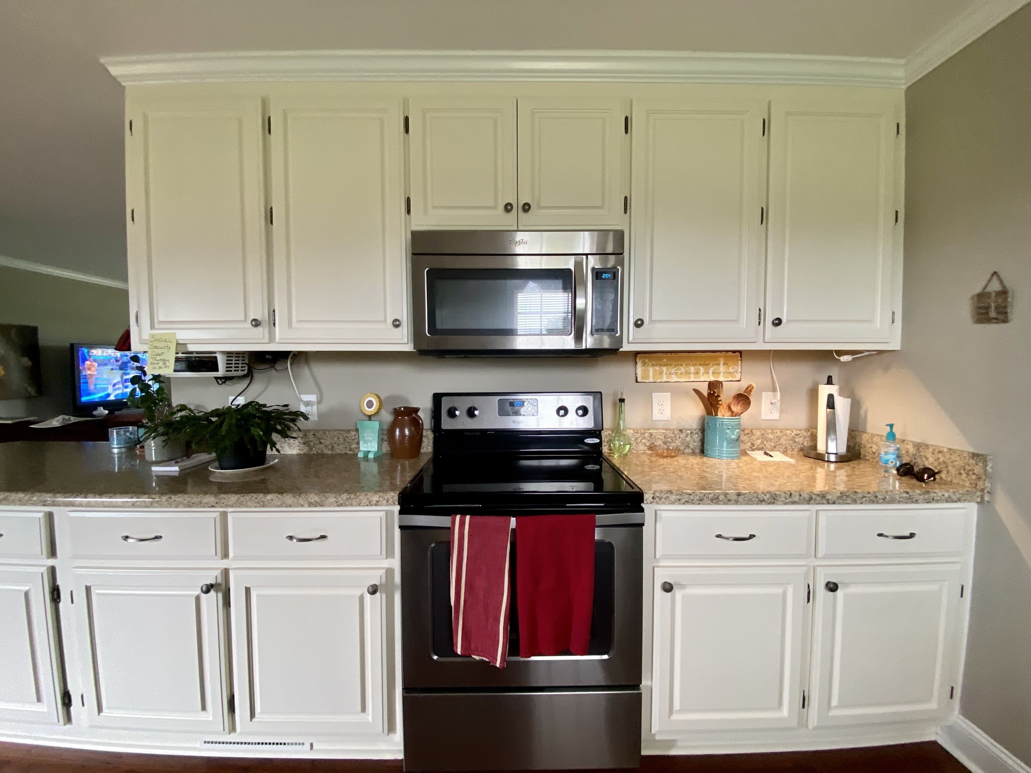 129 Dunn Fall River Road Leoma, TN 38468 - Photo 8 of 36 a kitchen with granite countertop a stove a sink and dishwasher with white cabinets