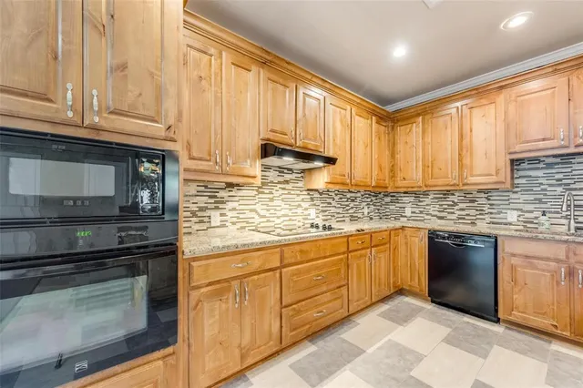 a kitchen with granite countertop cabinets stainless steel appliances and a counter space