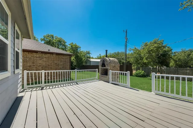 a view of deck with wooden floor and fence next to a yard