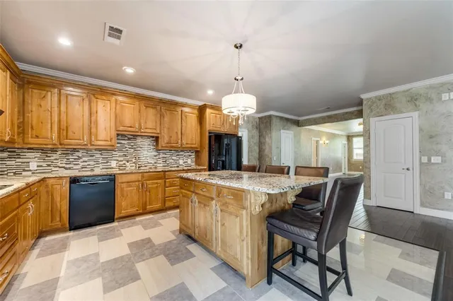 a large kitchen with granite countertop a stove a sink a dining table and chairs