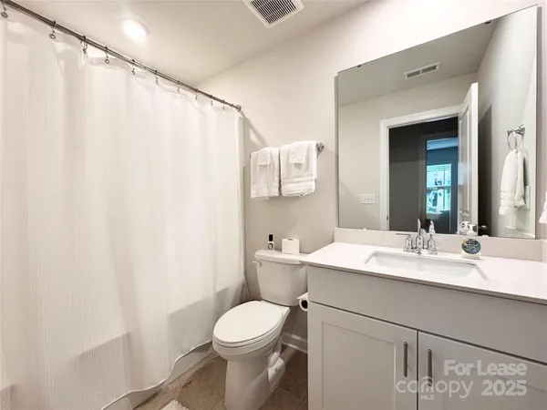a bathroom with a sink a toilet and shower curtain