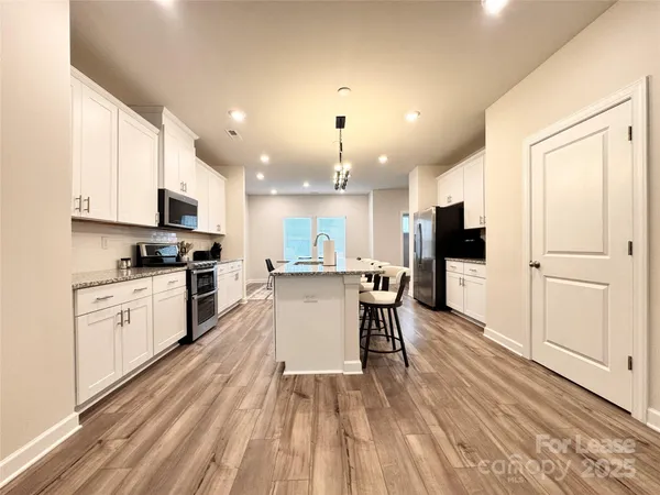 a kitchen with a sink stainless steel appliances and white cabinets