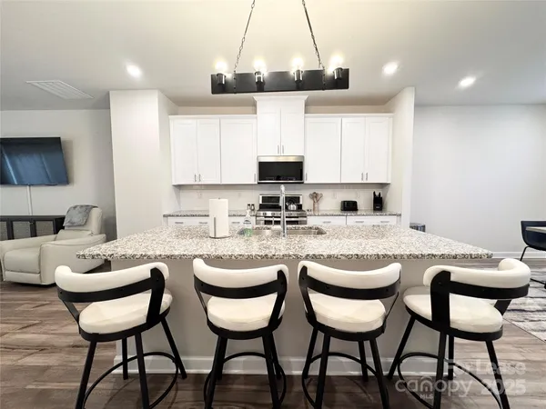 a kitchen with a dining table chairs and white cabinets