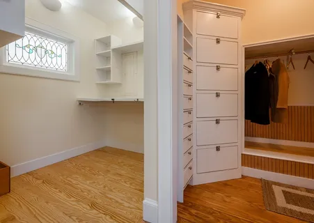 a view of walk in closet with window and wooden floor