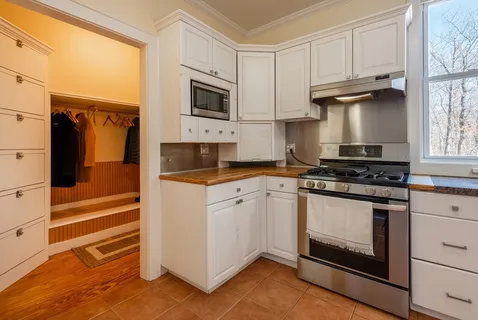 a kitchen with stainless steel appliances white cabinets and a stove top oven