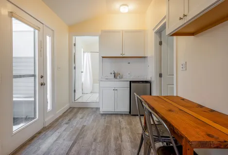 a kitchen with white cabinets and wooden floor
