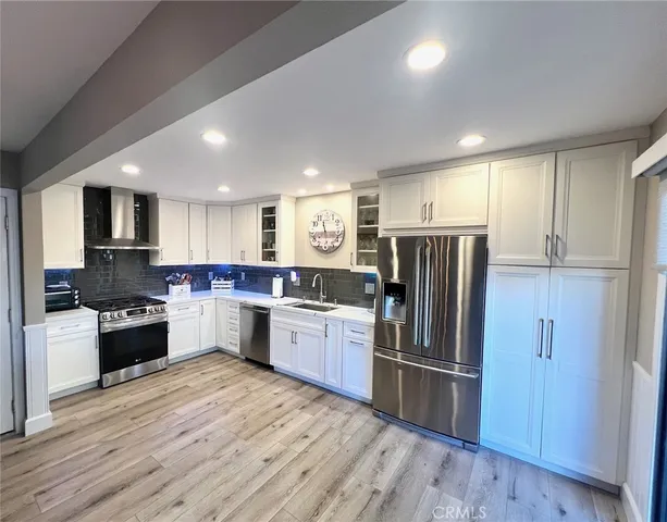 a kitchen with granite countertop a refrigerator stove top oven and sink