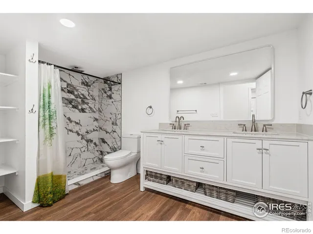 a bathroom with a double vanity sink mirror and toilet