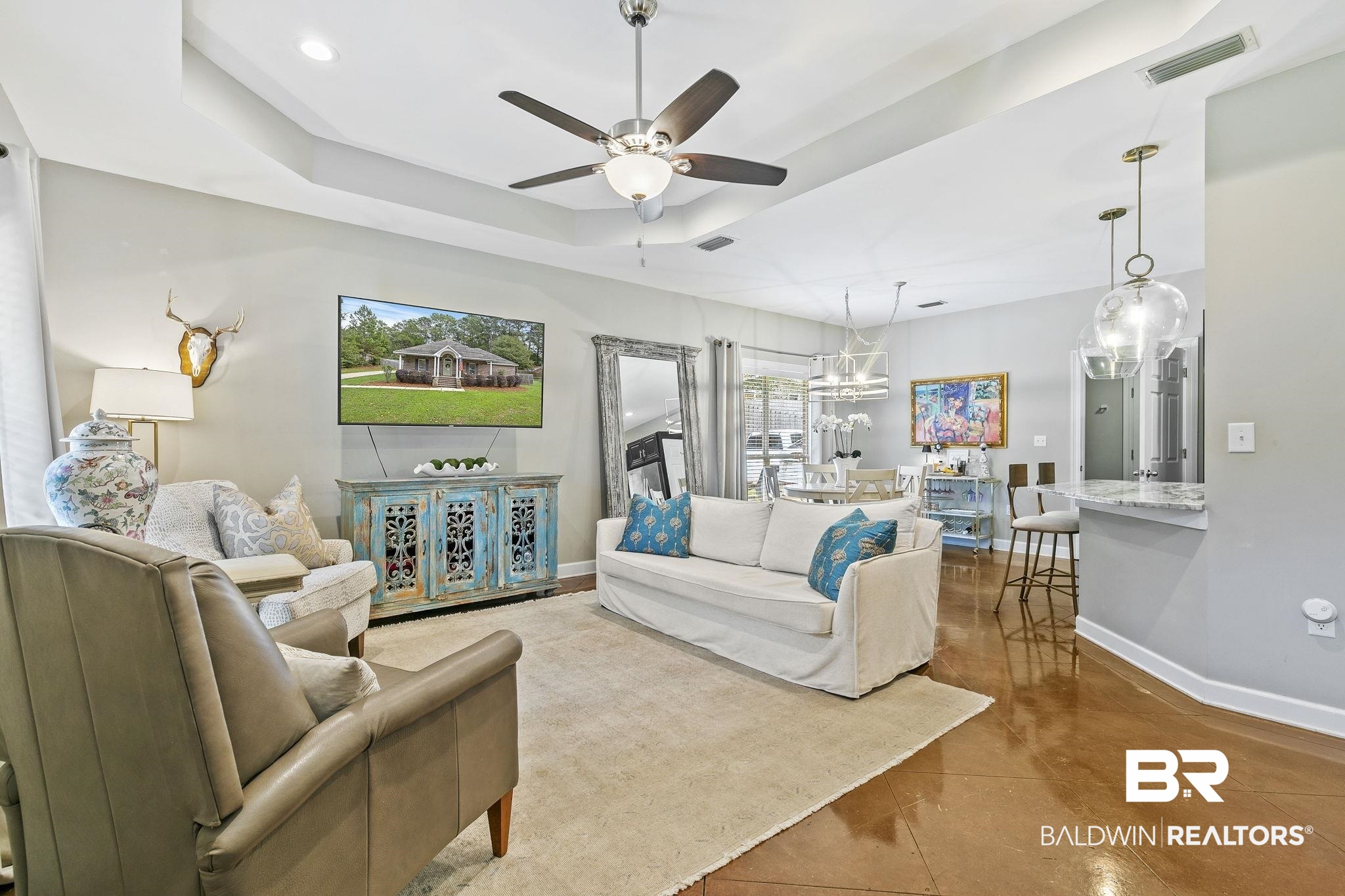 32072 Buzbee Road Daphne, AL 36527 - Photo 11 of 41 Living room featuring a raised ceiling, tile patterned flooring, a healthy amount of sunlight, and ceiling fan with notable chandelier