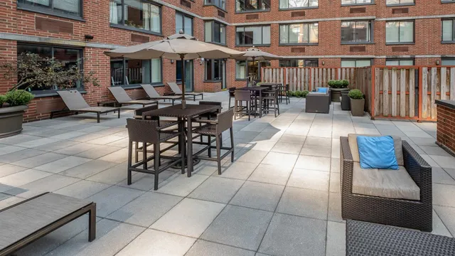 a view of a patio with couches table and chairs and potted plants