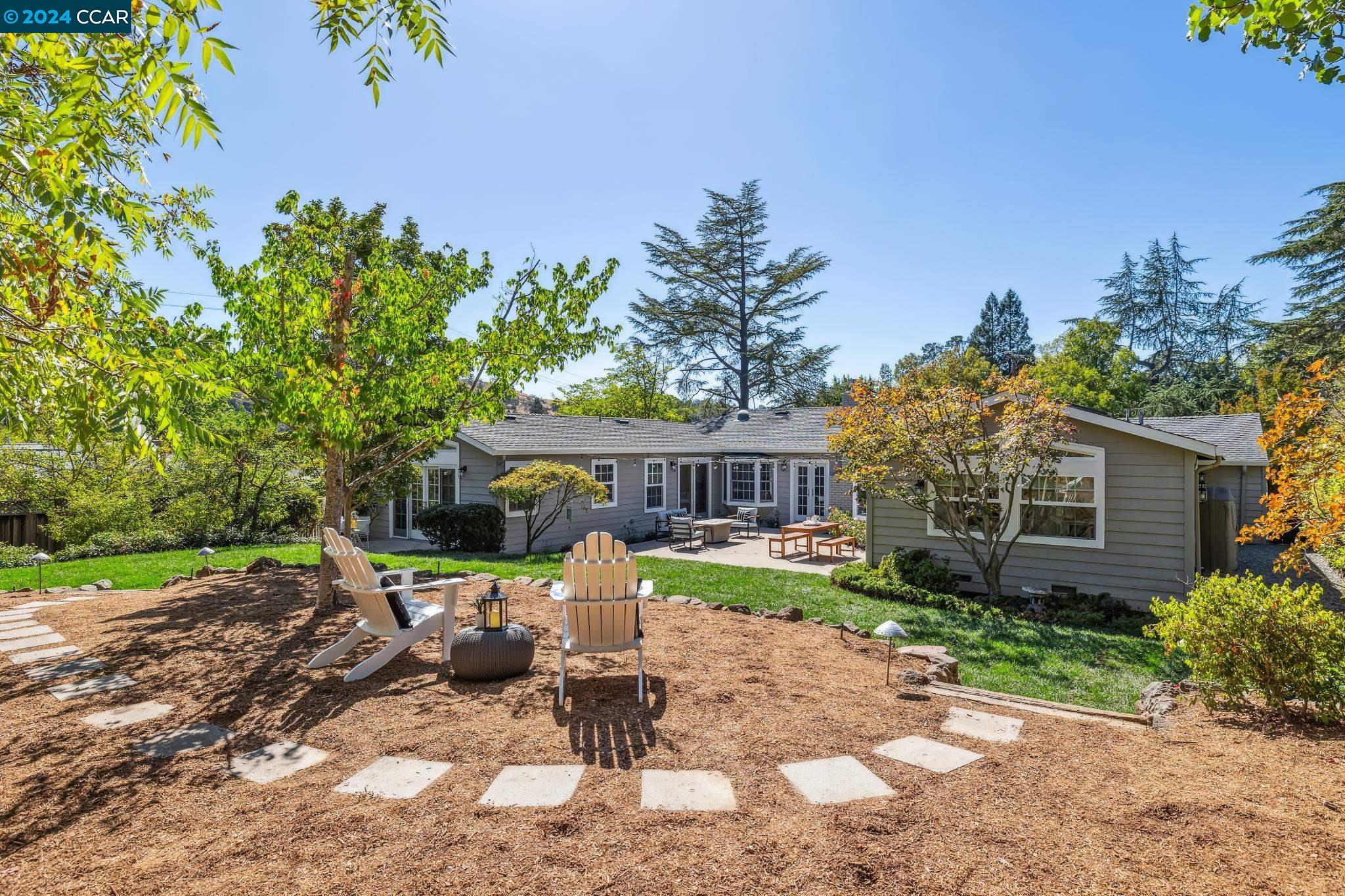 a view of a house with backyard sitting area and garden