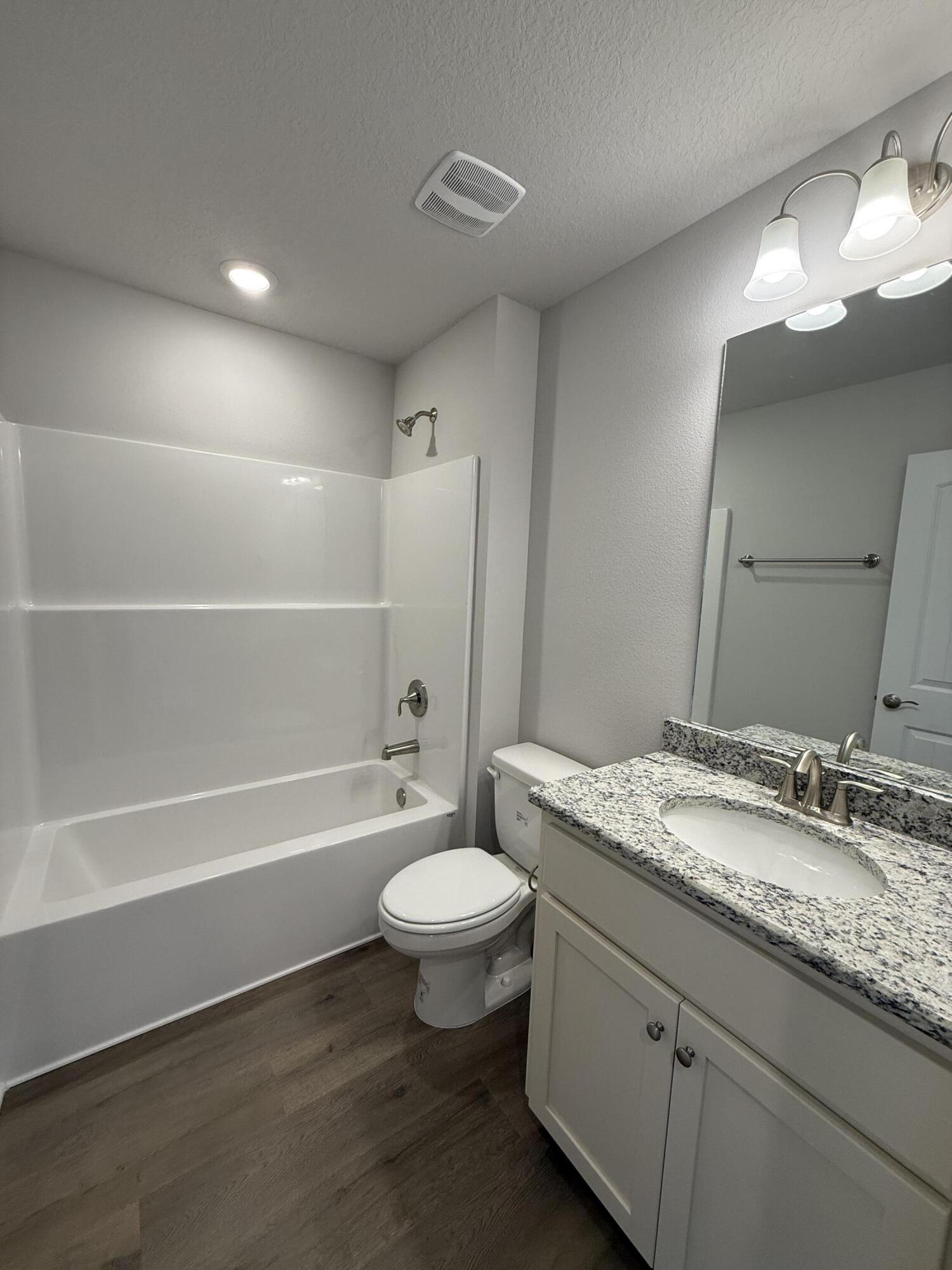 194 Ridgeway Circle Crestview, FL 32536 - Photo 6 of 25 a bathroom with a granite countertop sink toilet mirror and bathtub