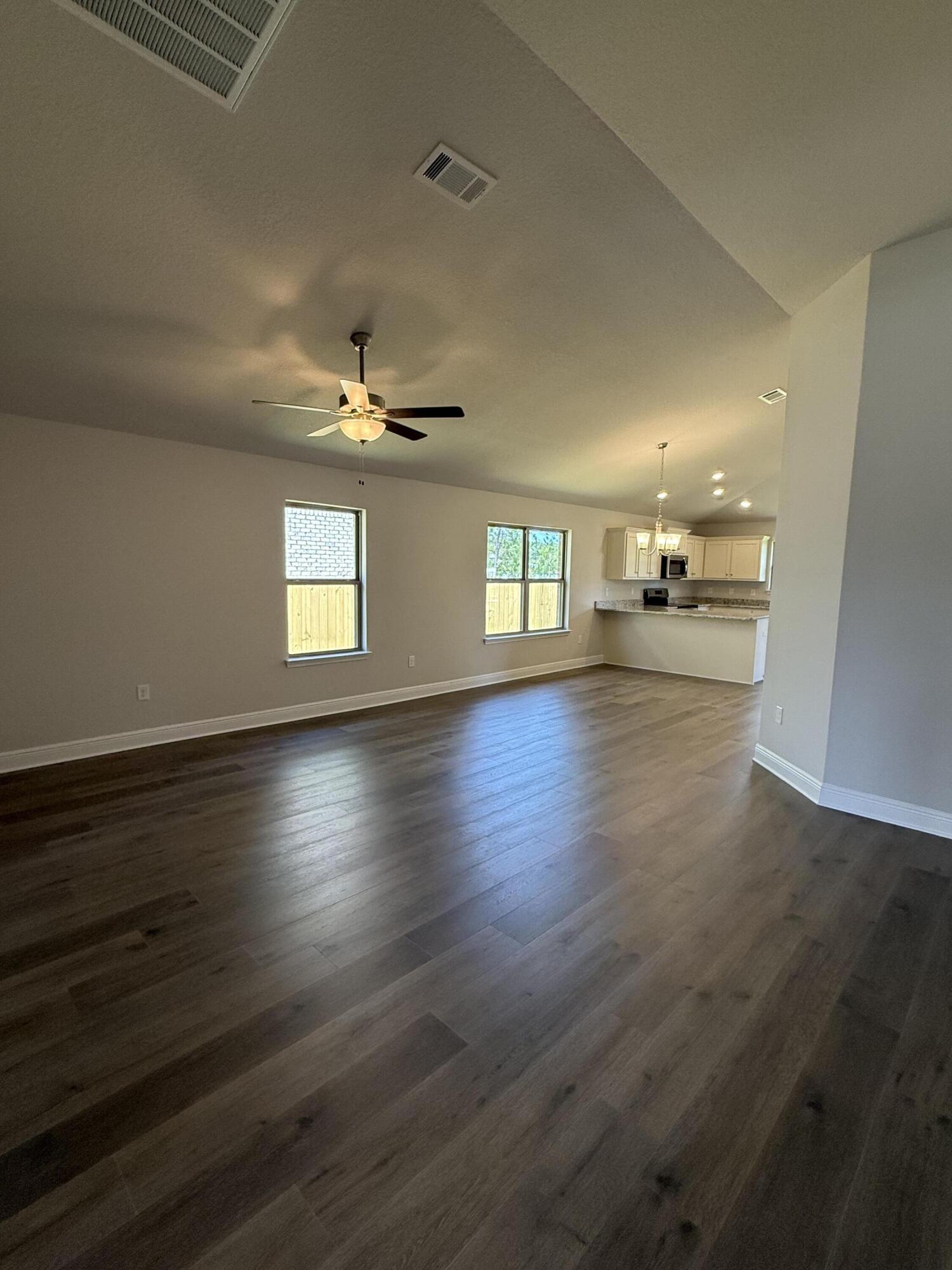 194 Ridgeway Circle Crestview, FL 32536 - Photo 8 of 25 a view of an empty room with wooden floor and a window