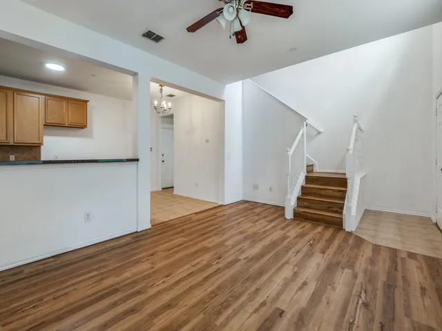 a view of empty room with wooden floor and stairs