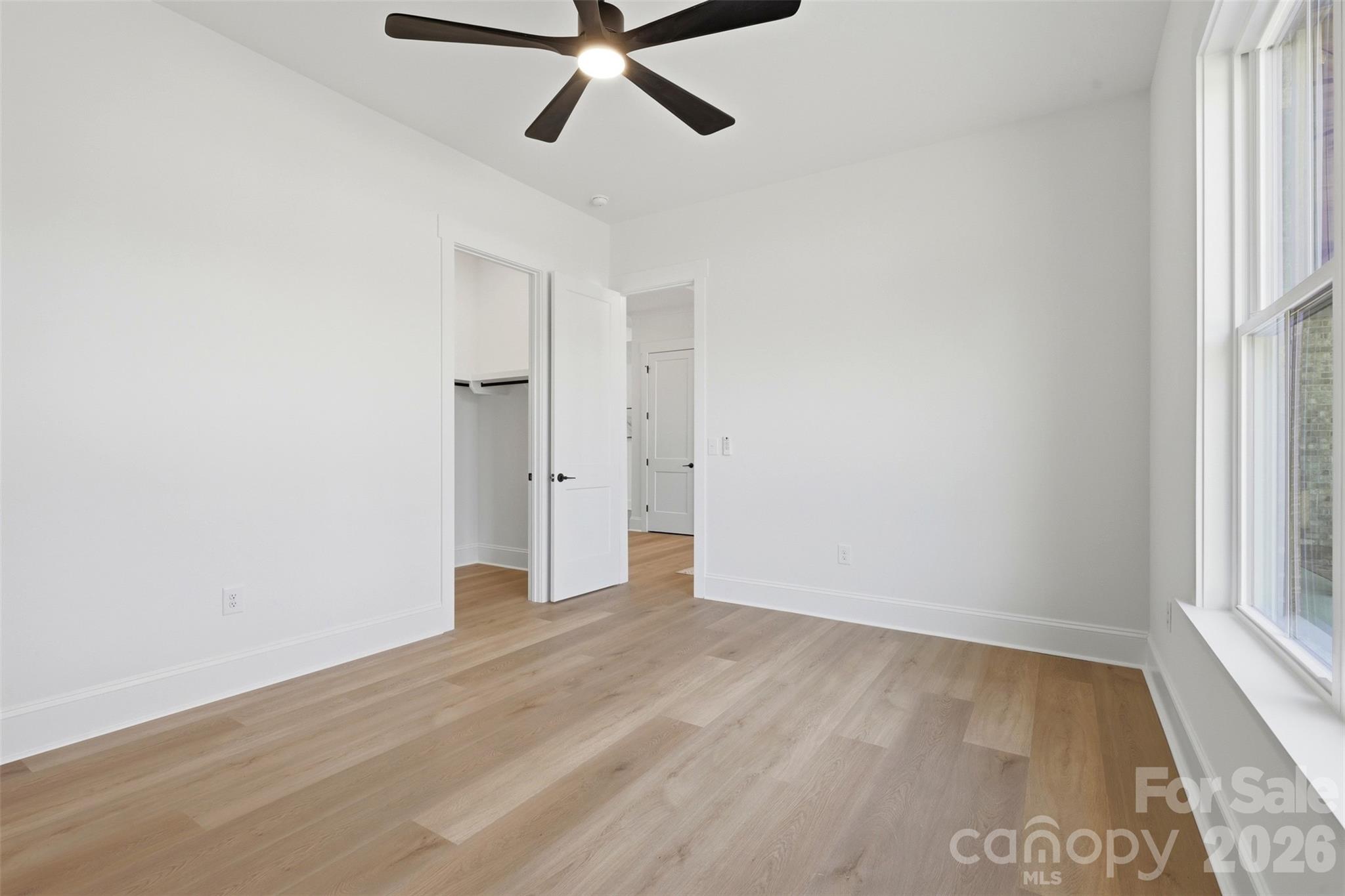 4734 Polk Ford Road Stanfield, NC 28163 - Photo 32 of 48 an empty room with wooden floor and windows