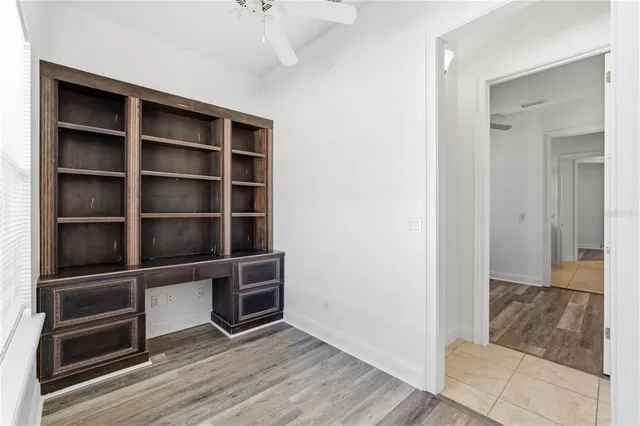 a view of an empty room with wooden floor and closet