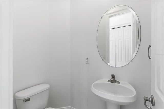 a bathroom with a sink a mirror and toilet