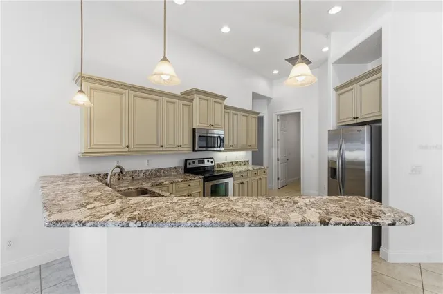 a kitchen with kitchen island granite countertop a sink and refrigerator