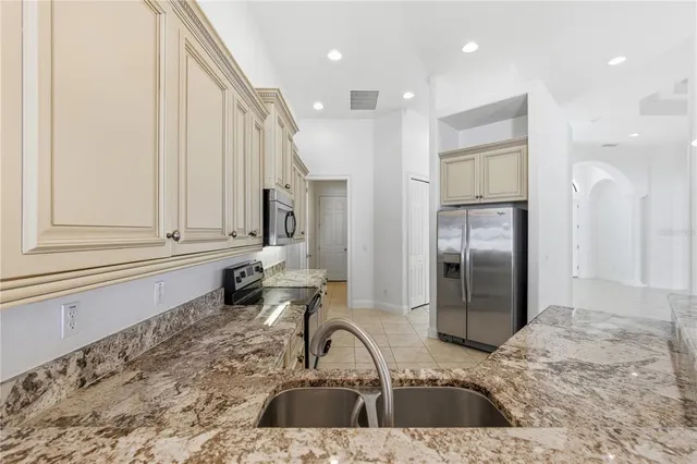 a kitchen with a refrigerator sink and cabinets