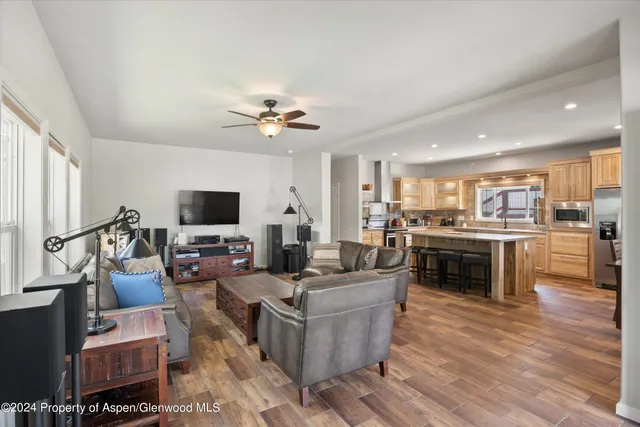 a living room with furniture kitchen view and a flat screen tv