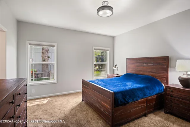 a bed sitting in a bedroom next to a window