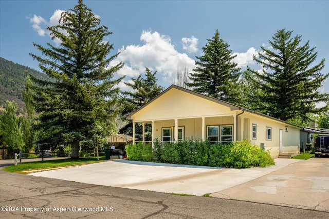 a front view of a house with a yard and trees
