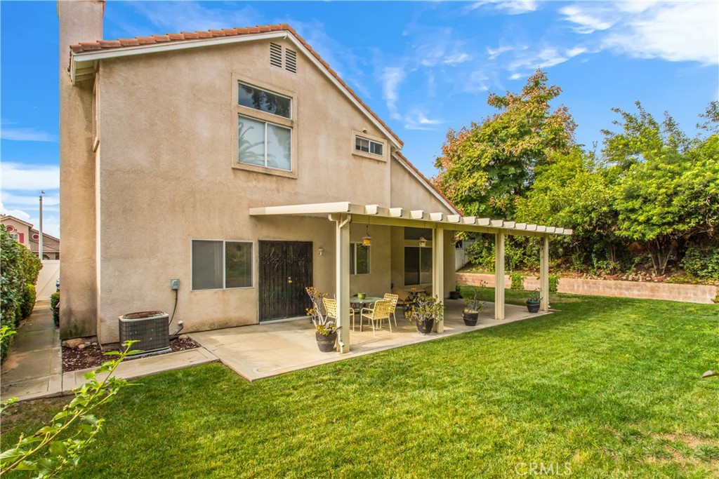 7693 Chanticleer Road Highland, CA 92346 - Photo 12 of 14 a front view of a house with a yard table and chairs