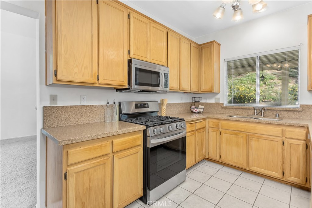 7693 Chanticleer Road Highland, CA 92346 - Photo 2 of 14 a kitchen with stainless steel appliances granite countertop a stove a sink and a microwave
