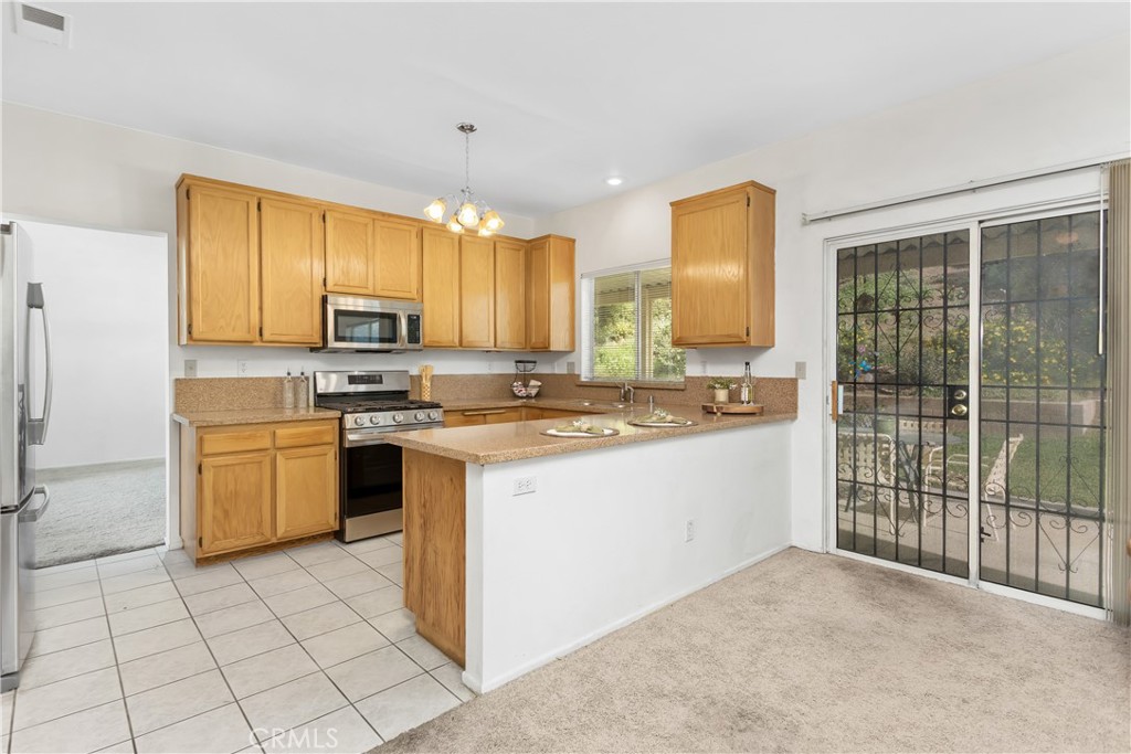 7693 Chanticleer Road Highland, CA 92346 - Photo 3 of 14 a kitchen with a sink cabinets and appliances