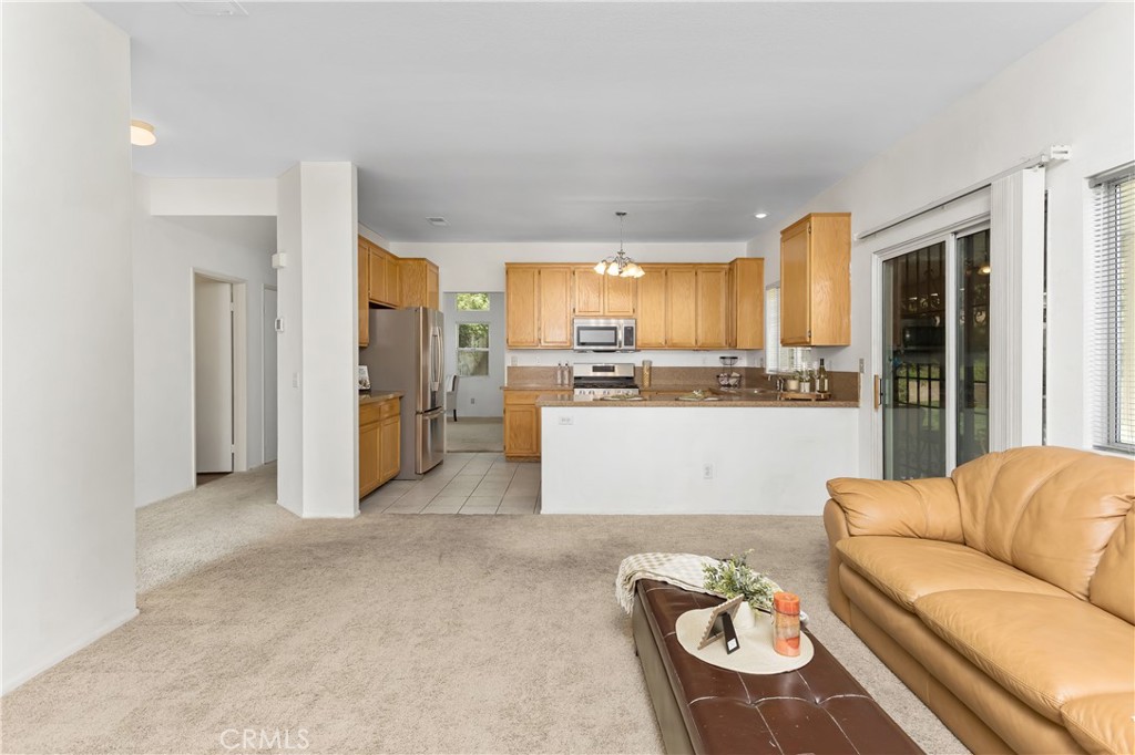 7693 Chanticleer Road Highland, CA 92346 - Photo 6 of 14 a living room with furniture and kitchen view