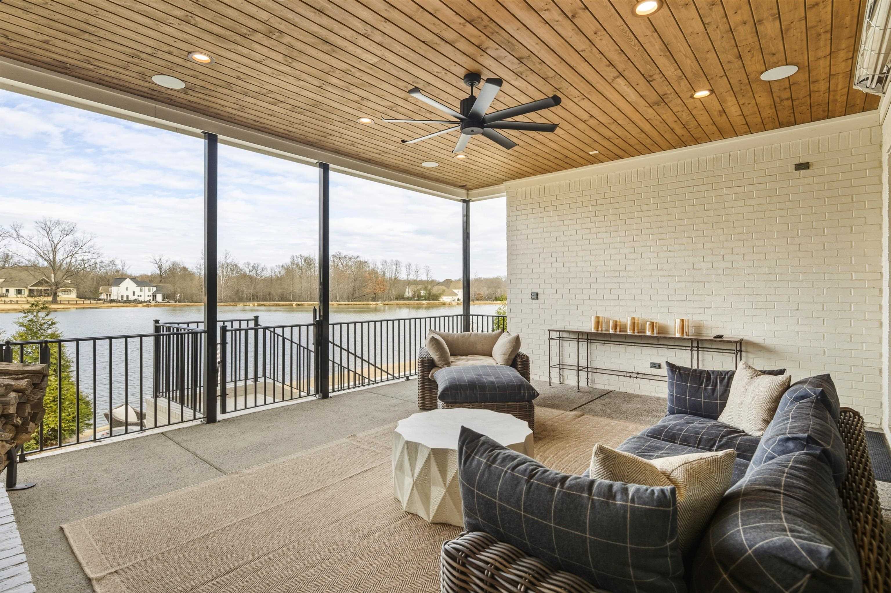 160 North Lake Road Piperton, TN 38017 - Photo 7 of 40 Sunroom featuring brick wall, a wall of windows, carpet, a water view, and wood ceiling