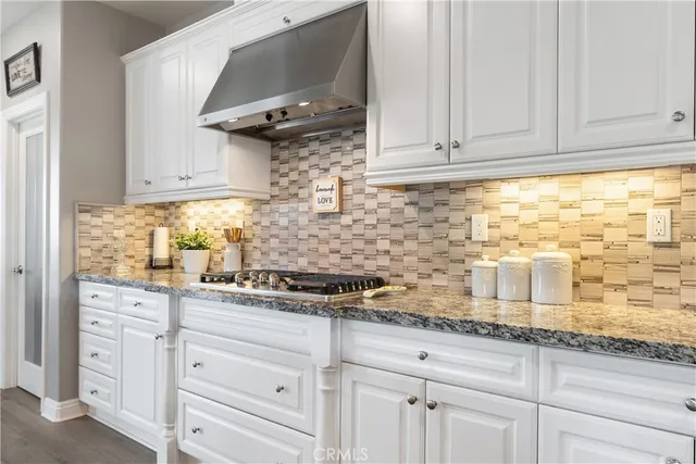 a kitchen with white cabinets and a stove