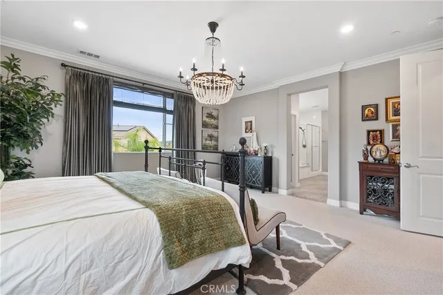 a spacious bedroom with a bed and a chandelier