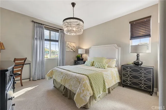a bedroom with a bed chandelier and a window