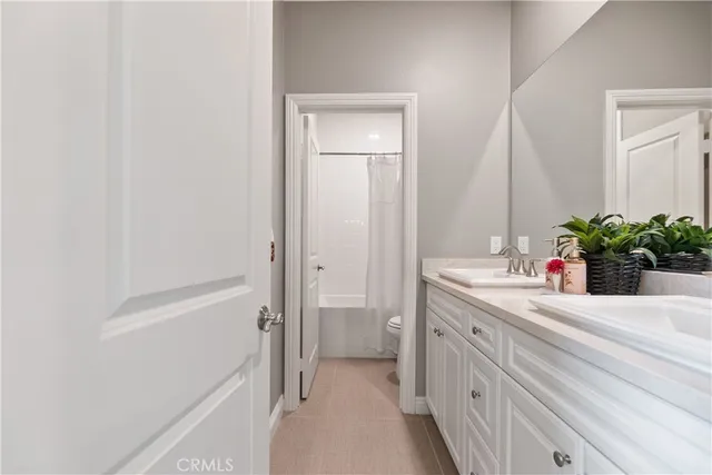 a bathroom with a double vanity sink a mirror and a shower