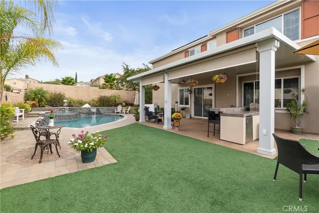 a view of a patio with table and chairs potted plants and palm tree