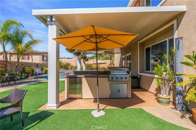 a view of a patio with table and chairs under an umbrella