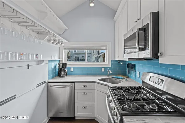 a kitchen with stainless steel appliances a sink stove and cabinets