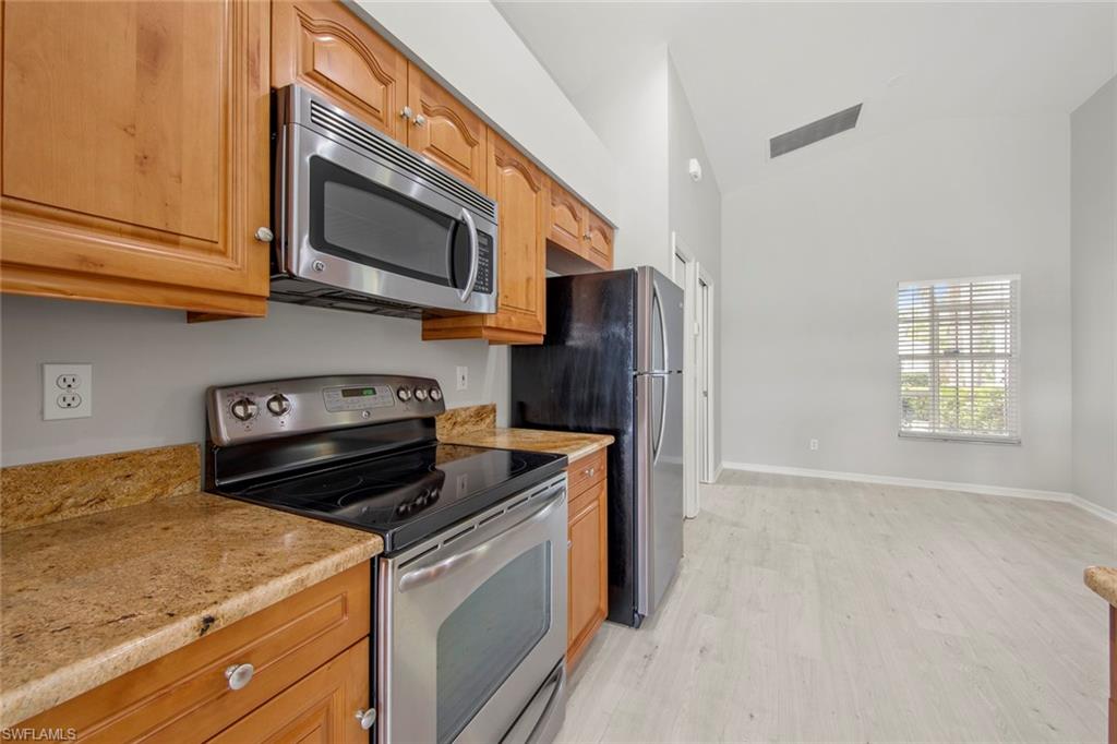 21629 Windham Run Estero, FL 33928 - Photo 11 of 48 a kitchen with stainless steel appliances granite countertop a refrigerator stove and microwave