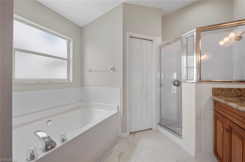 21629 Windham Run Estero, FL 33928 - Photo 16 of 48 a bathroom with a bathtub and a shower