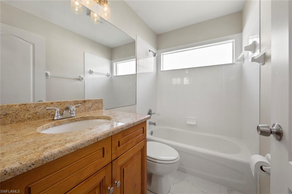 21629 Windham Run Estero, FL 33928 - Photo 20 of 48 a bathroom with a granite countertop sink a toilet and bathtub