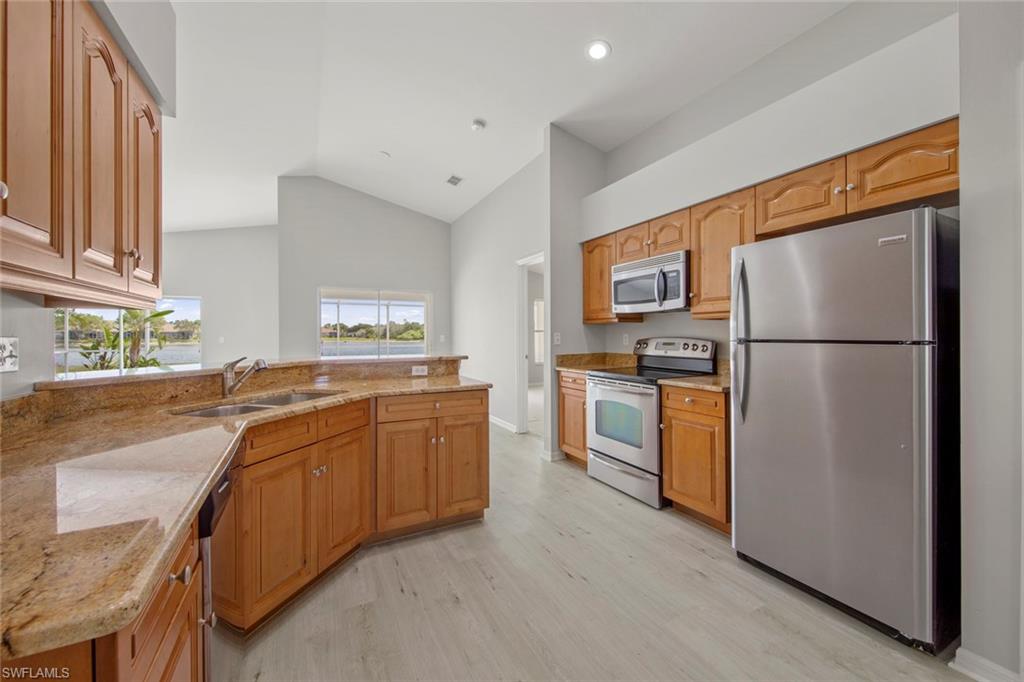 21629 Windham Run Estero, FL 33928 - Photo 9 of 48 a kitchen with stainless steel appliances granite countertop a refrigerator a stove a sink and a refrigerator