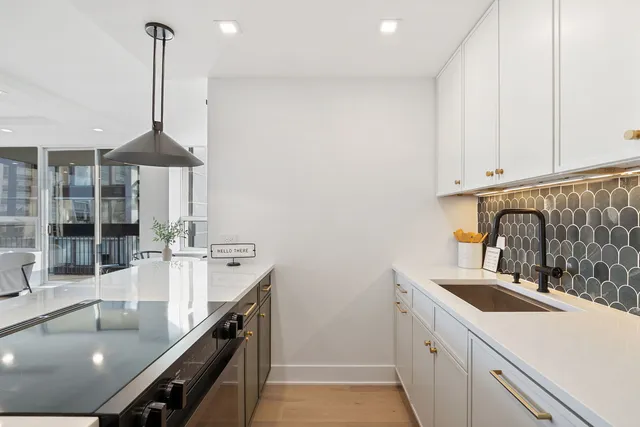 a kitchen with kitchen island a stove a sink and chandelier