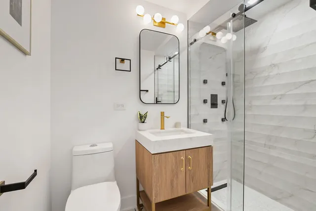 a bathroom with a sink toilet vanity and shower