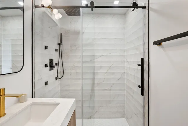a bathroom with a granite countertop shower sink and vanity