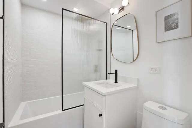 a bathroom with a sink and mirror with toilet