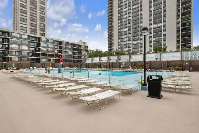 a swimming pool with outdoor seating and city view