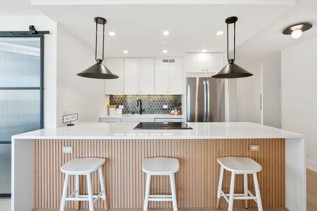 a kitchen with stainless steel appliances a sink a table and chairs